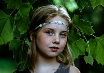 Girl with leaves looking at the camera